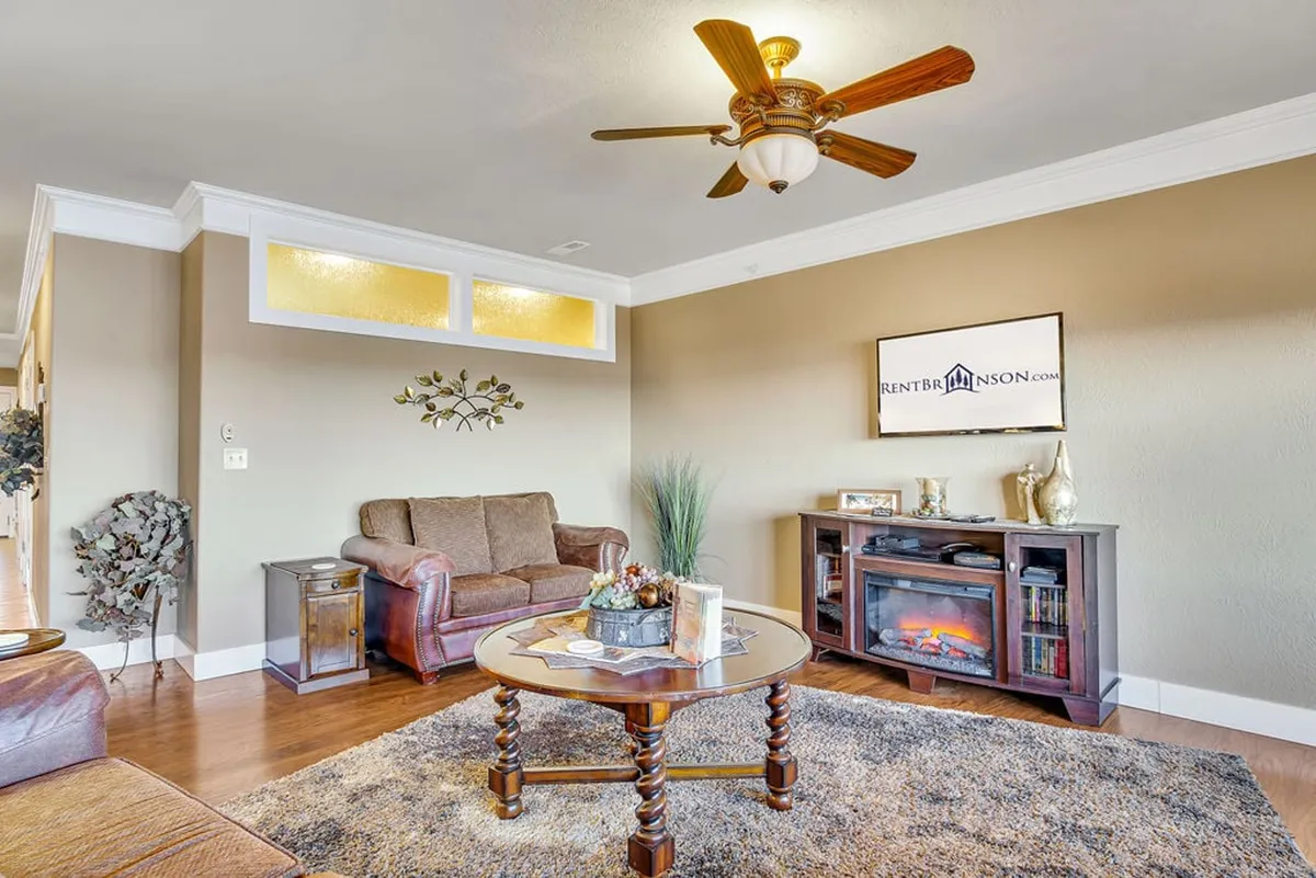 A welcoming living room with a plush sofa (potentially a sleeper sofa), coffee table, television, and a decorative plant, all arranged in a cozy setting that invites relaxation or entertainment.